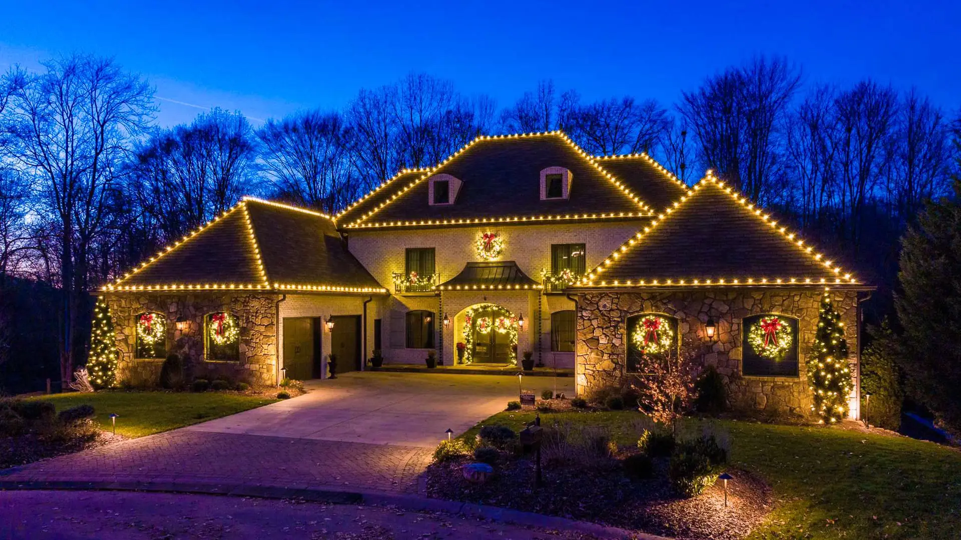 Maison illuminée de lumières de Noël blanc chaud sur la toiture et les colonnes